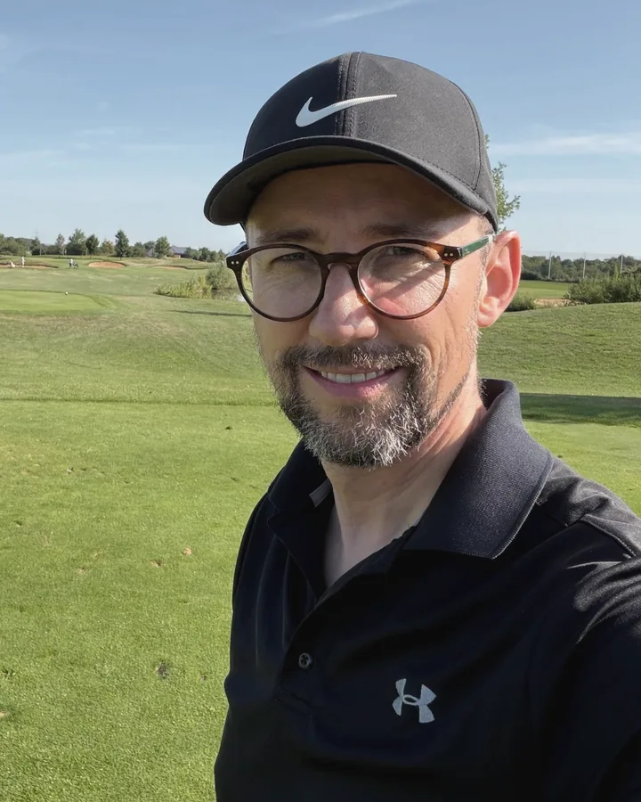 Christoph Maurer auf dem Golfplatz, mit Kappe und Brille